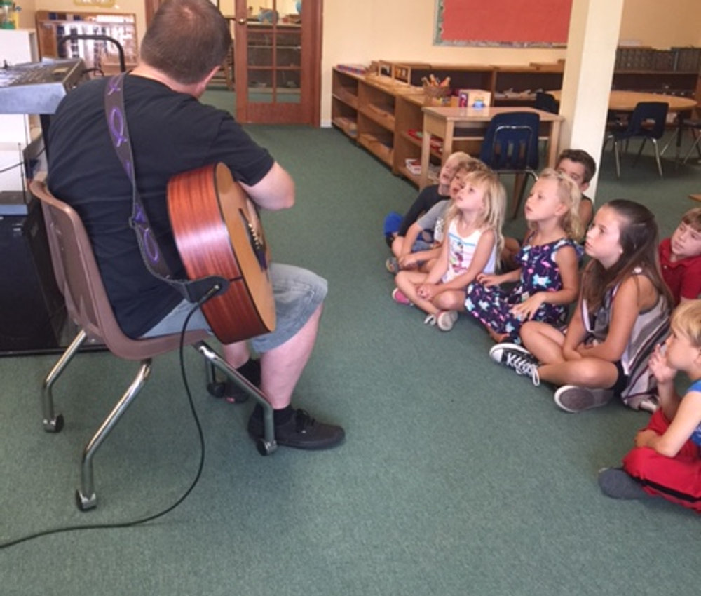Children gathered on the floor for a music circle in the classroom